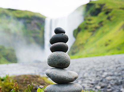 rock files / cairn in front of a relaxing waterfall